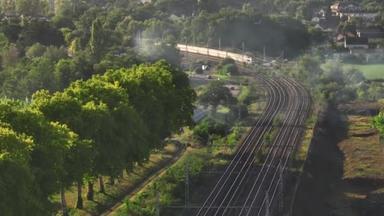 高速客运列车在铁路上行驶的空中景象.高角线通过高速列车在农村夏季乡村景观.列车运动空中视图,视差效应.高质量4k